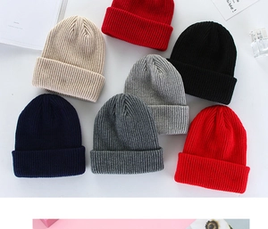 Close-up of winter knitted beanies in various colors including red, black, and beige