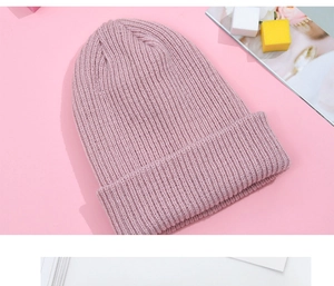 Close-up of pink winter beanie showing soft thick ribbed knit texture and material