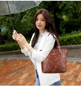 Detail of dark brown tote bag featuring premium woven texture and leather shoulder strap