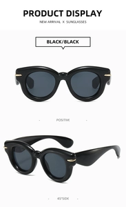Front and 45-degree angle views of black oversized sunglasses with gold metal accents