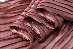 Detail shot of dusty pink pleated satin fabric with elegant shimmer and fine textures