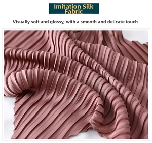 Detailed texture of pleated pink faux silk scarf showing soft sheen and smooth fabric