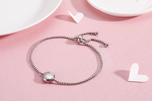 Detail of silver Taurus constellation charm on an adjustable beaded steel bracelet