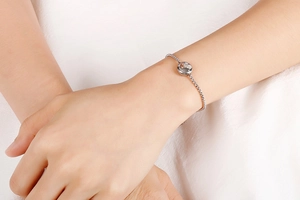 Close-up of minimalist silver Zodica chain bracelet with small round pendant on wrist