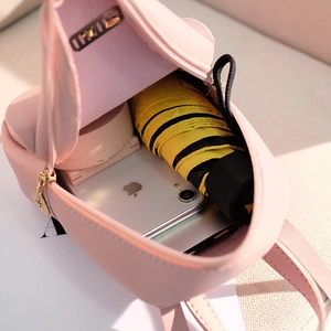 Pink faux leather mini backpack showing internal capacity for phone and umbrella