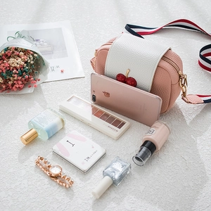 Pink and white leather crossbody bag with cherry metal buckle and colorful striped strap