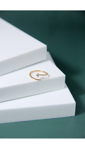 Detailed close-up of a delicate gold shooting star ring with a sparkling round zircon