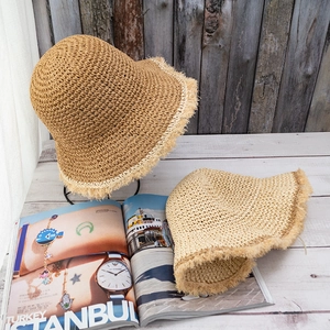 Close-up of handmade crochet straw hat featuring a stylish frayed raw edge and woven texture