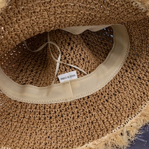 Detailed macro view of the inner sweatband and adjustable drawstring on a straw sun hat