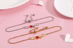 Detail of adjustable heart heartbeat bracelets in gold and silver with red stones