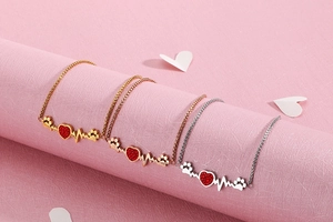 Detail of heart rhythm bracelets in gold, rose gold and silver with red zircon stones