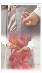 Detail of striped kitchen apron with coral fleece hand towels and a large front pocket