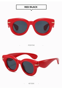 Detailed view of red chunky oversized sunglasses with dark lenses and gold metal accents