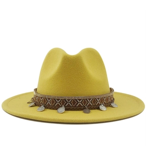 Detail of yellow wool felt fedora featuring ethnic woven band and silver metal coins