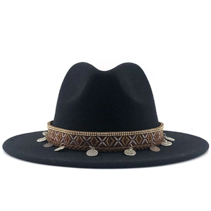 Detail of black fedora hat featuring ethnic woven band and silver metal charms