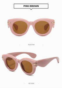 Detail of pink fashion sunglasses with brown lenses and gold metallic temple accents