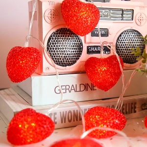 Romantic red heart-shaped LED string lights wrapped around vintage radio decor