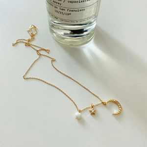 Detail of S925 silver necklace with moon star pendants and round white pearl charms