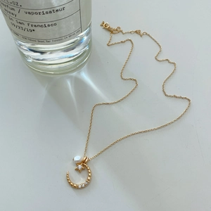 Detail of S925 sterling silver sun and moon necklace with embedded diamonds and pearl