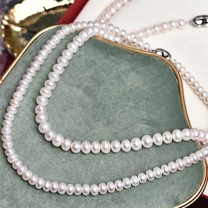 Elegant natural freshwater pearl necklace displayed on green velvet with golden accents