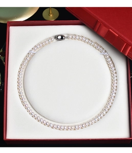 Macro view of natural freshwater pearl necklace with silver clasp in a red gift box
