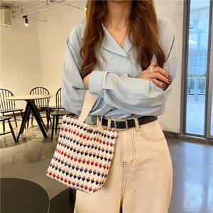 Dettaglio della piccola borsa tote con motivi geometrici e trama a coste sottili