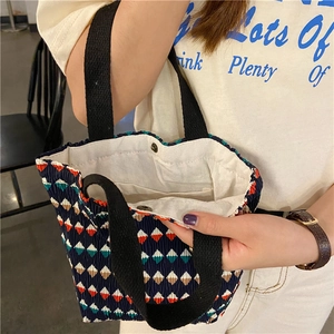 Dettaglio della piccola borsa con motivi geometrici, tessuto stropicciato e chiusura magnetica