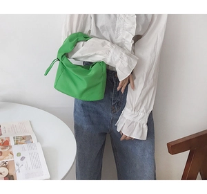 Détail du sac baguette vert vif avec poignée nouée et texture en nylon plissé élégant