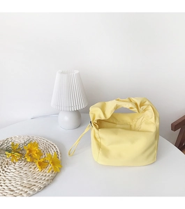 Gros plan sur un sac baguette jaune vif en nylon au style minimaliste épuré