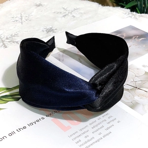 Detailed view of the knotted wide satin headband featuring deep blue and black contrast panels
