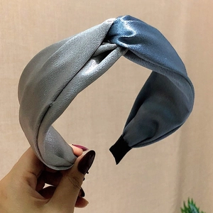 Detail of cross-knot satin headband in silver-grey and blue-grey glossy fabric