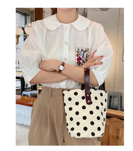 Polka dot canvas bucket bag styled with casual outfit in a cozy cafe setting