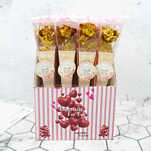 Detail of four golden foil roses individually wrapped in a pink striped gift display box