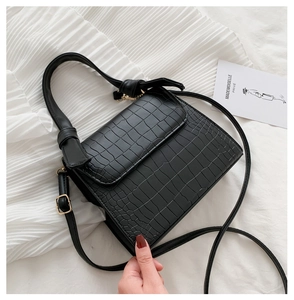 Top view of black croc-embossed small handbag with gold hardware and top handle