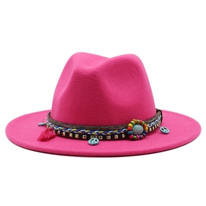 Detail of rose red wool fedora featuring colorful beads, turquoise, and pink tassels