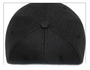 Top detail of the black baseball cap showing reinforced six-panel stitching and top button