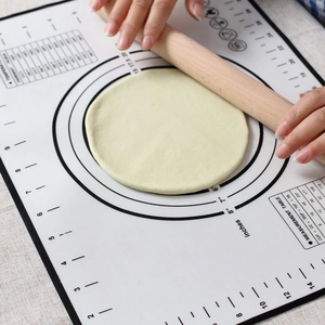 Close-up of silicone baking mat with measurement markings and dough being rolled
