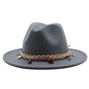 Detail of grey wool fedora hat with ethnic woven band, shells, and decorative pom-poms