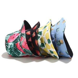 Detail view of four tropical fruit print bucket hats in pink, black, yellow and light blue