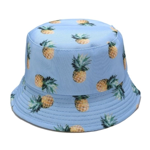 Close-up of light blue sun hat featuring vibrant yellow pineapple print and canvas texture