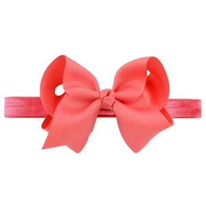 Detailed view of handmade coral pink grosgrain ribbon bow on an elastic baby headband