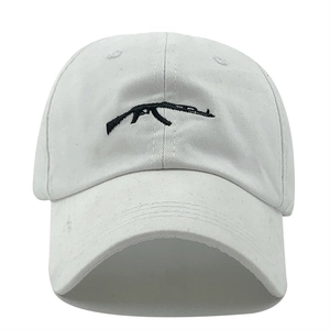 White cotton baseball cap featuring black AK-47 rifle embroidery on front panel