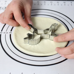 Detail of metal unicorn cookie cutter being used on a silicone pastry mat with scale