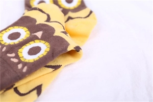 Close-up of cute owl pattern embroidery on yellow knitted cotton ankle socks for women