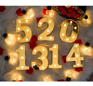 Close-up of gold mirror LED number lights 520 and 1314 on white plush rug for decoration
