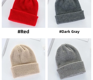 Detail of ribbed knit beanies in red, dark grey, beige, and marl grey for winter warmth