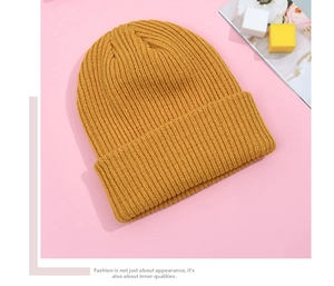 Detailed view of bright yellow ribbed knit beanie with stylish folded cuff and soft texture