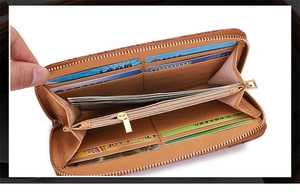 Macro detail of brown litchi leather long wallet with multiple card slots and zipper pocket