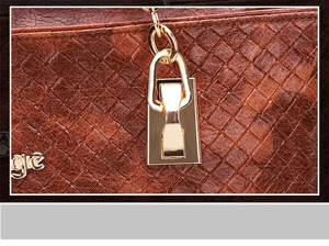 Close-up of brown woven leather texture with a polished gold metal lock buckle