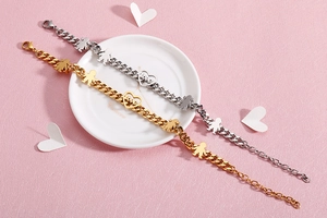 Close-up of gold and silver thick chain bracelets with boy girl and love heart charms